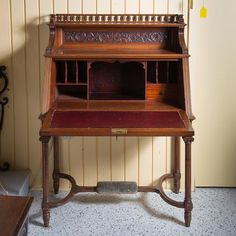 an old wooden desk sitting in front of a wall