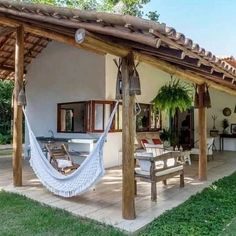 a hammock hanging from the side of a house next to a patio area