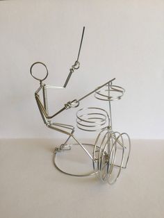 a wire sculpture of a man riding a bike with wheels and spokes attached to the handlebars