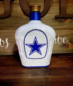 a blue and white bottle sitting on top of a wooden table