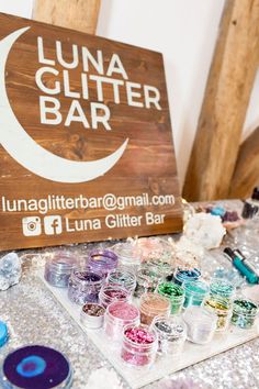 the lunaa glitter bar sign is next to many different colored gels on display