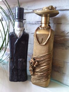 two decorative bottles sitting on top of a counter next to a plant in a vase