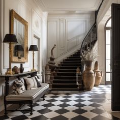 a black and white checkered floor in a house with stairs leading up to the second floor