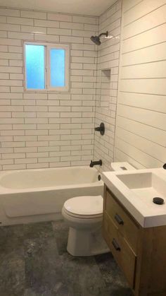 a white toilet sitting next to a bath tub in a bathroom