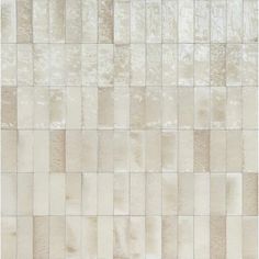 a white tile wall with different shades of beiges and creams on the tiles