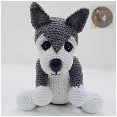 a crocheted gray and white dog sitting on the ground