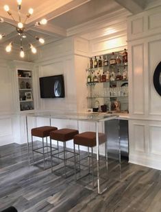 a bar with four stools in front of it and a clock on the wall