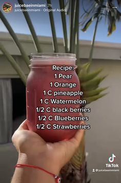 a person holding up a jar filled with fruit and text that reads recipe 1 pear orange pineapple watermelon 12 c blueberries 12 ounce strawberries 12 strawberry