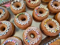 there are many donuts decorated with letters on the doughnuts and frosting