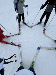 four skiers are standing in the middle of a circle with their skis on