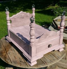 a pink bed sitting on top of a wooden table