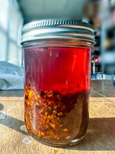 a jar filled with liquid sitting on top of a wooden table