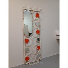 a mirror that is hanging on the wall next to a shelf with some kind of object in it