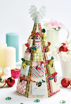 a small christmas tree made out of many different types of cards and tags on it