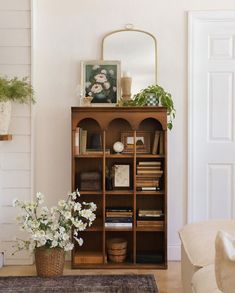 a living room with a book shelf and flowers