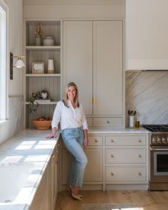 a woman leaning on the counter in a kitchen