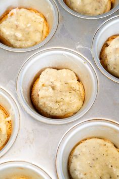 muffins with white icing in a pan ready to be baked