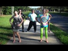 three people are standing on the sidewalk with their arms around each other