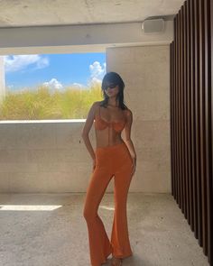 a woman in an orange outfit posing for the camera