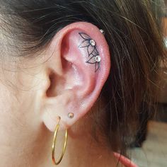 a close up of a person's ear with a tattoo on the top of it