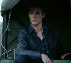 a young man sitting in the back of a truck