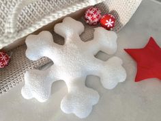 a snowflake with red and white decorations on it next to a christmas ornament