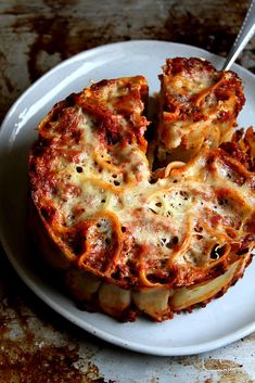 a white plate topped with lasagna covered in cheese