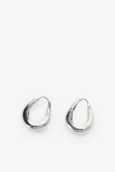 Find poetry in the everyday with our Sisley Hoops. Elegant and ever-so-chunky, these oval ornaments are crafted from sterling silver with either 18k gold or white gold plating to complement any look. Featuring a post back closure and polished finish. Each pair includes a Marcella-branded vegan leather travel case for safe storage and easy travel. | Available in one size. Approximately .5” (1.5 cm) in height, and .3" (.8 cm) in width. In silver, white gold plated sterling silver. In gold, 18KT ye Silver Oval Jewelry For Everyday, Sterling Silver Rounded Jewelry, Silver Oval Earrings For Everyday, Everyday Teardrop Jewelry With Shiny Finish, Silver Oval Tarnish Resistant Hoop Earrings, Everyday Oval Jewelry With Shiny Finish, Trendy Oval Jewelry For Everyday, Oval Jewelry With Shiny Finish For Everyday, Safe Storage