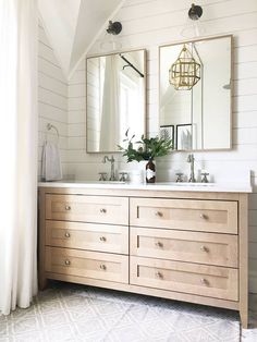 a bathroom with two sinks and mirrors on the wall