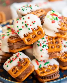 a blue plate topped with pretzels covered in frosting and sprinkles