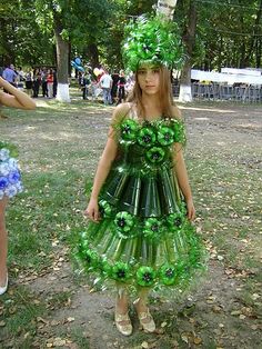 a woman in a dress made out of plastic bottles with flowers on the top and bottom