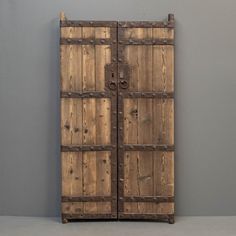 an old wooden door is shown against a gray wall