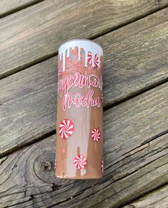 a cup sitting on top of a wooden table next to candy canes and candies