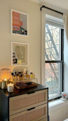 a bedroom with a dresser, window and pictures on the wall next to each other