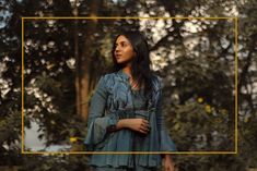 a woman standing in front of some trees