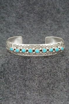 This turquoise and sterling silver bracelet was made by Navajo silversmith Grace Silver. The inside is signed GS and stamped sterling. Size: 5 3/4" (will fit up to a 6 3/4" wrist) Gap: 1" Width: 1/2" Free shipping on all orders! We ship with USPS and always include tracking. All orders ship within a day of payment. Returns are accepted up to 30 days after you receive your order. Just send us a message. Our shop offers cash back or store credit. The item must be returned in new condition. Etched Turquoise Sterling Silver Jewelry, Engraved Turquoise Sterling Silver Bracelet Gift, Western Style Blue Sterling Silver Bracelet Gift, Southwestern Style Stamped Blue Bracelets, Southwestern Etched Turquoise Jewelry, Southwestern Turquoise Etched Jewelry, Southwestern Style Etched Turquoise Jewelry, Stamped Turquoise Bracelet, Turquoise Stamped Bracelet