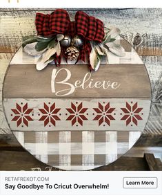 a wooden sign that says believe on it with red and white snowflakes