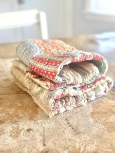 three pieces of cloth stacked on top of each other in front of a white chair