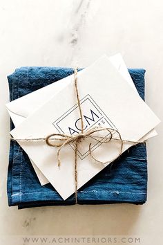 an envelope wrapped in twine and tied with rope on top of blue napkins