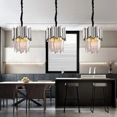 A modern kitchen features sleek cabinetry, a central island with two black bar stools, and a dining table with brown chairs. Above the island hang three Gio Crystal Kitchen Light Fixtures from Morsale.com, adorned with K9 Crystal pieces, adding a touch of sophistication and elegance to the stainless steel-accented space. Chrome Lighting, Kitchen Island Pendant Light, Foyer Hallway, Deeply In Love, Modern Crystal Chandelier, Chandelier Decor, Stainless Steel Lighting, Crystal Pendant Lighting, Chrome Chandeliers