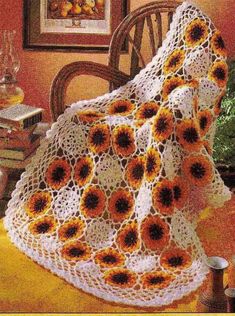 a crocheted blanket with sunflowers on it