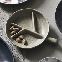 a plate with nuts in it on the floor next to other plates and bowls,