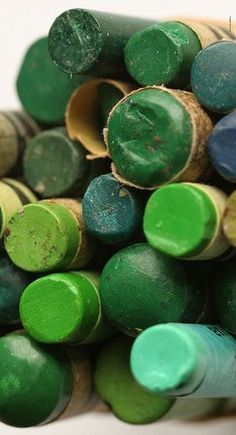 green and blue crayons are stacked on top of each other in a pile