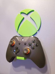 a close up of a game controller on a wall with a green logo above it