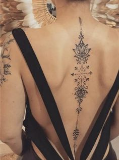 the back of a woman's body with tattoos on her upper and lower back