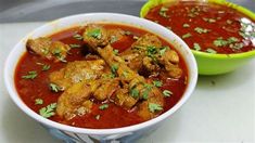 two bowls filled with meat and sauce on top of a white counter next to each other