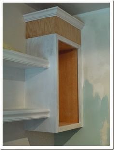 an unfinished kitchen cabinet in the corner of a room