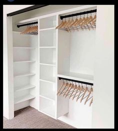 an empty white closet with wooden clothes hangers