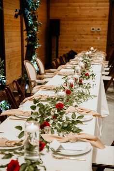 a long table is set with place settings and flowers