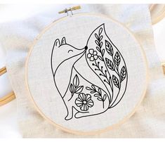 a hand embroidery pattern with a dolphin and flowers on it, in the shape of a circle